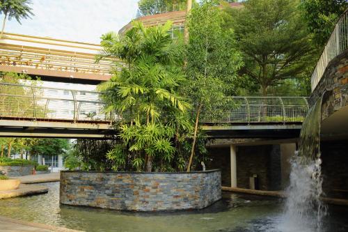 a fountain in the middle of a pond with a bridge at Afiniti 2BR Sunlit Designer - 3 Min To Legoland in Iskandar Puteri