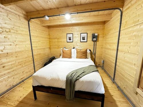 a bedroom with a bed in a wooden room at Sunken Escapes Cabin 9 in New Minas
