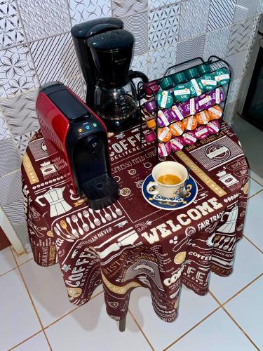 een tafel met een kop koffie en een telefoon bij Casa do Anjo in Fernando de Noronha