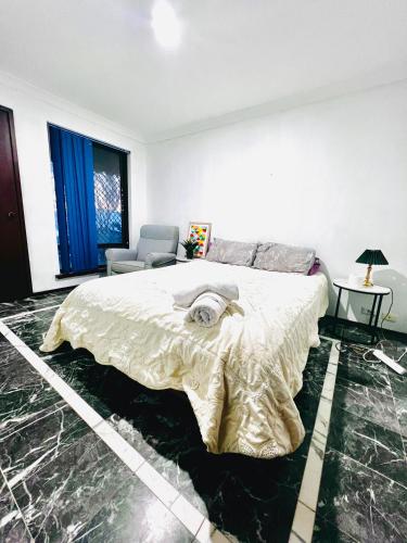 a white bedroom with a bed and a chair at 28 OFF Affordable Beautiful Queen Bedroom Near City Swan River Fremantle University in Perth