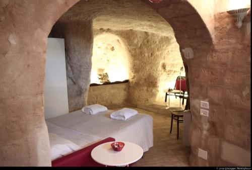 マテーラにあるCasa Vacanza Il Fontanino nel cuore dei Sassiの石壁のベッドルーム1室