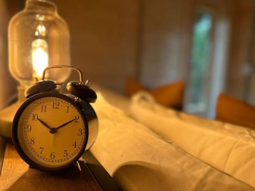 an alarm clock sitting on top of a table at Sunken Escapes Cabin 10 in New Minas