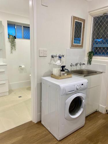 a washing machine in a bathroom with a sink at Modern Stylish House in Craigie in Perth