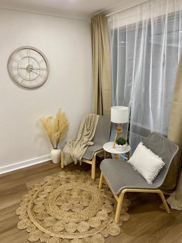 a living room with two chairs and a rug at Modern Stylish House in Craigie in Perth