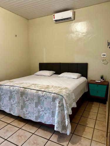 a bedroom with a bed with a blanket on it at Sítio Encanto do Delta in Tutóia
