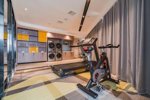 a gym with a treadmill and a exercise bike at Echarm International Hotel Guangzhou South Railway Station Zhongcun Metro Station Branch - Free Shuttle Bus to Canton Fair Complex During Canton Fair Period & Free Deliver Service to Guangzhou Baiyun International Airport in Guangzhou