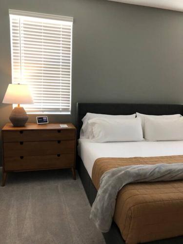 a bedroom with two beds and a lamp on a nightstand at Cottageza at Harvest in Queen Creek