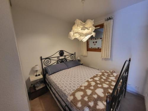 une chambre avec un lit et un lustre dans l'établissement Charmant appartement 2 pièces avec balcon à Montgenèvre - FR-1-266-235, à Montgenèvre