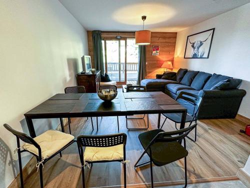 un salon avec une table, des chaises et un canapé dans l'établissement Appartement cosy 2 ch, 7 pers, pied de pistes, parking, wifi - FR-1-356-505, à Valmorel