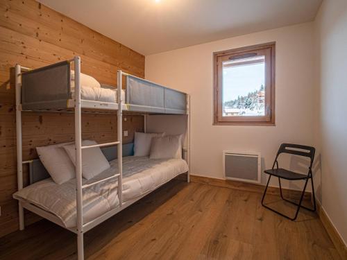 une chambre avec deux lits superposés et une fenêtre dans l'établissement Appartement cosy 2 ch, 7 pers, pied de pistes, parking, wifi - FR-1-356-505, à Valmorel