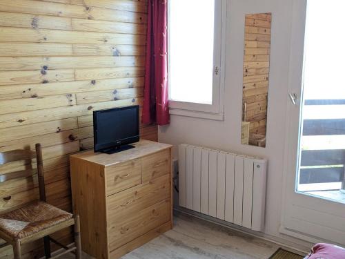 Cette chambre dispose d'une télévision sur un mur en bois. dans l'établissement Studio cosy pour 3 pers avec balcon et équipements de confort aux Adrets-Prapoutel - FR-1-557-130, à Les Adrets