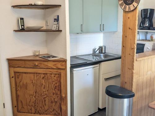 une petite cuisine avec un évier et une cuisinière dans l'établissement Studio cabine 4 pers, pied des pistes, balcon, exposé sud - FR-1-557-132, à Les Adrets