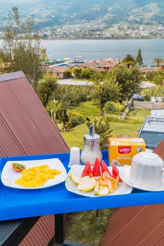 a blue table with two plates of fruit on it at Hospedaje Campo Lago y Glamping in Otavalo