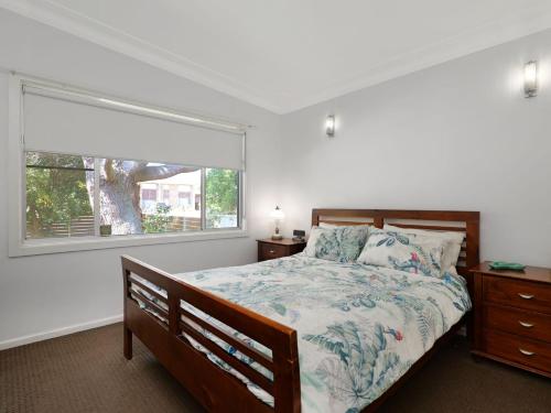 a bedroom with a bed and a large window at Cosy Retreat in Nelson Bay in Nelson Bay