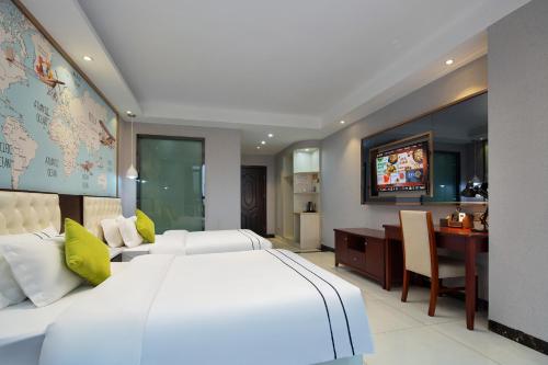a bedroom with a large white bed and a desk at 北极星酒店（长沙高铁南站店） in Changsha