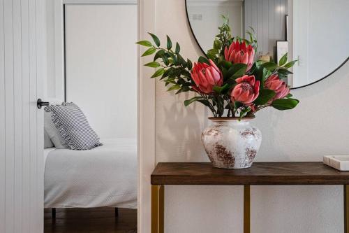 a vase of flowers on a table in a bedroom at Frankie's Place- lux & stylish in Wodonga