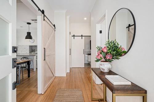 a hallway with a mirror and a table with flowers at Frankie's Place- lux & stylish in Wodonga
