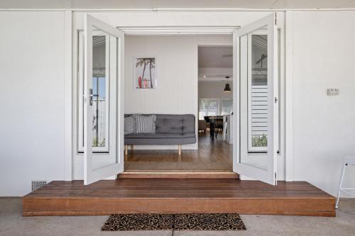 a living room with an open door with a couch at Frankie's Place- lux & stylish in Wodonga