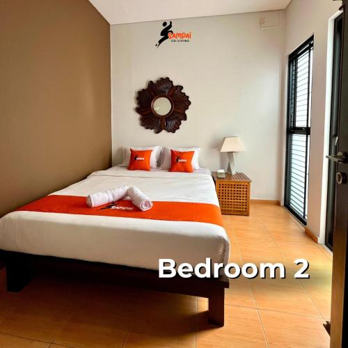 a bedroom with a bed with orange pillows at Sampai Villa Amarajota in Kejayan