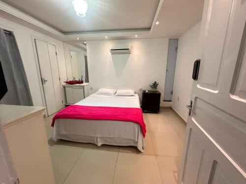 a bedroom with a bed with a pink blanket at Pousada 10 de maio in Itaperuna