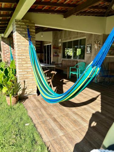 a blue hammock on a patio with a house at Sítio Encanto do Delta in Tutóia