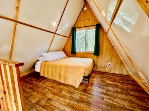 a bed in a small room with a window at Roberts Lodge in Tok