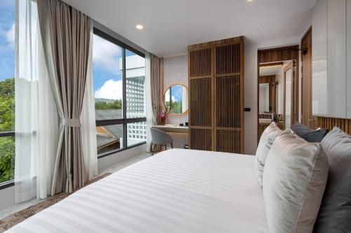 a bedroom with a large bed and a large window at MANDLA VILLAS COLLECTION, Villa Tanya Rawai in Rawai Beach