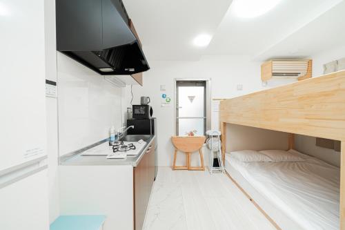 a kitchen with a sink and a bed in a room at Momo-stay Ikebukuro in Tokyo