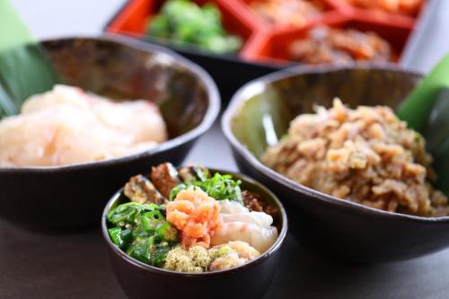 a group of bowls of food on a table at KAMENOI HOTEL Kamogawa in Kamogawa