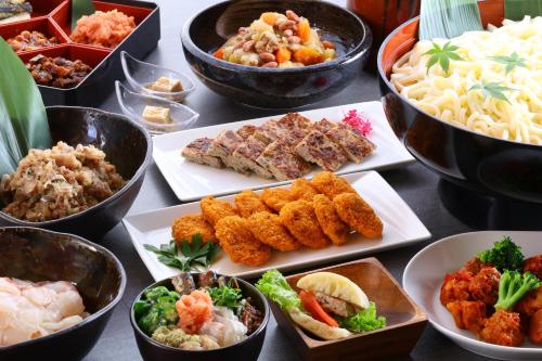 a table topped with plates of different types of food at KAMENOI HOTEL Kamogawa in Kamogawa