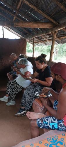 a group of people sitting under a hut at Hotel white house mahiyanganaya in Mahiyangana