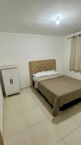 ein Schlafzimmer mit einem Bett und einem kleinen Schrank in der Unterkunft Van Gogh residence Apartamento no Veneza in Ipatinga