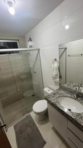ein Badezimmer mit Toilette, Waschbecken und Dusche in der Unterkunft Van Gogh residence Apartamento no Veneza in Ipatinga