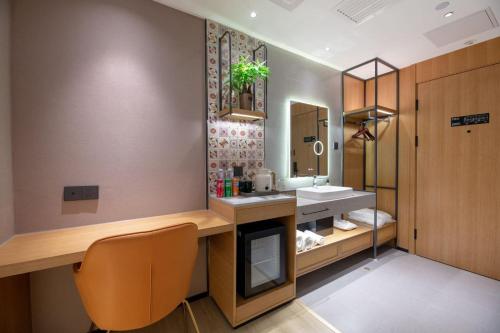 un bagno con lavandino e specchio di Shijiazhuang Changan Wanda Plaza Jianhua City Plaza Qiuguo Hotel a Shijiazhuang