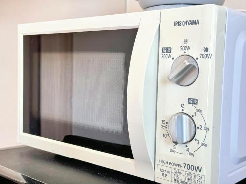a microwave oven with its door open on a counter at Juso AFP Apartment Hotel in Osaka