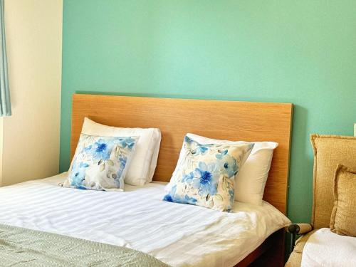 a bedroom with a bed with blue and white pillows at Juso AFP Apartment Hotel in Osaka