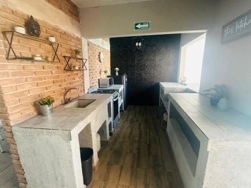 a kitchen with a sink and a stove at Vela Villa Jardin in Torreón