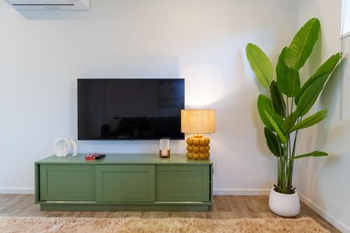 a living room with a green cabinet and a plant at Spacious Stay near Avon River with Carpark in Linwood