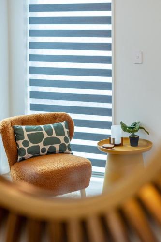 a chair with a pillow in a room with a window at Spacious Stay near Avon River with Carpark in Linwood