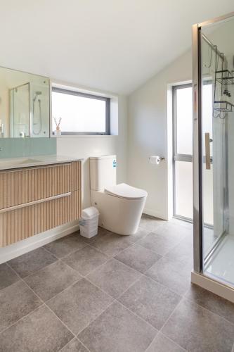 a bathroom with a toilet and a glass shower at Spacious Stay near Avon River with Carpark in Linwood