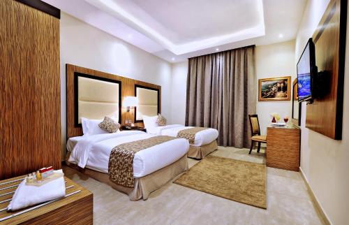 um quarto de hotel com duas camas e uma televisão de ecrã plano em Luxury villas for rent em Jidá