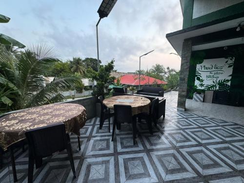 a patio with tables and chairs on a balcony at Phuenics de galera in Puerto Galera