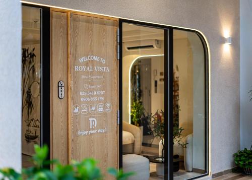 a wooden door with a sign on it at The Royal Vista - Phu My Hung in Ho Chi Minh City