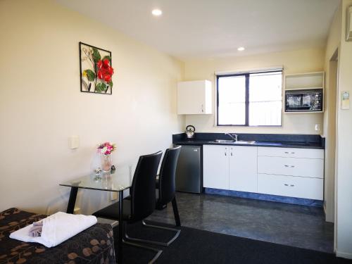 a small kitchen with a table and a sink at Aston Court Motel in Blenheim