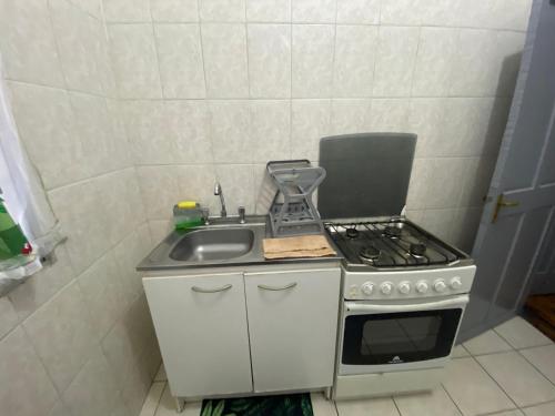 a small kitchen with a stove and a sink at Habitación 3 con baño compartido en Providencia CASA ROMÁN in Santiago