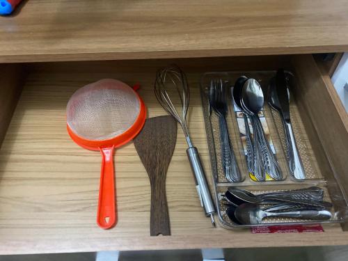 a wooden drawer with utensils and a red strainer at Habitación 3 con baño compartido en Providencia CASA ROMÁN in Santiago