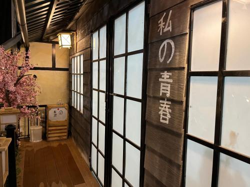 a hallway with windows and a wall with writing on it at Hanvy Garden in Ap My Quo