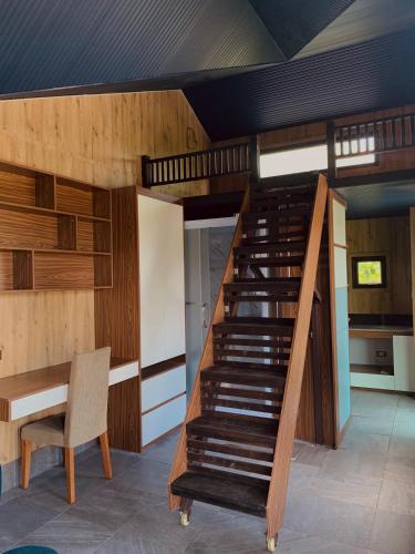a staircase in a room with a table and a chair at Halo Retreat in Hòa Bình
