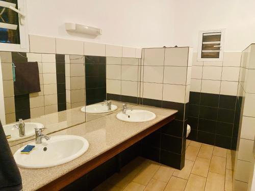 a bathroom with two sinks and two mirrors at Appartement T4 Standing Diégo-Suarez in Antsiranana