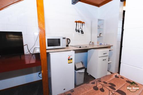 a small kitchen with a refrigerator and a microwave at New Haven Motel in Auckland